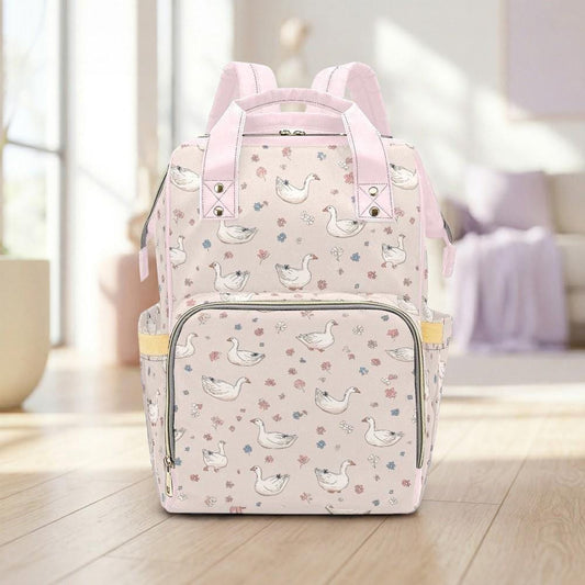 A pink backpack with a pattern of white ducks and flowers on a wooden floor.