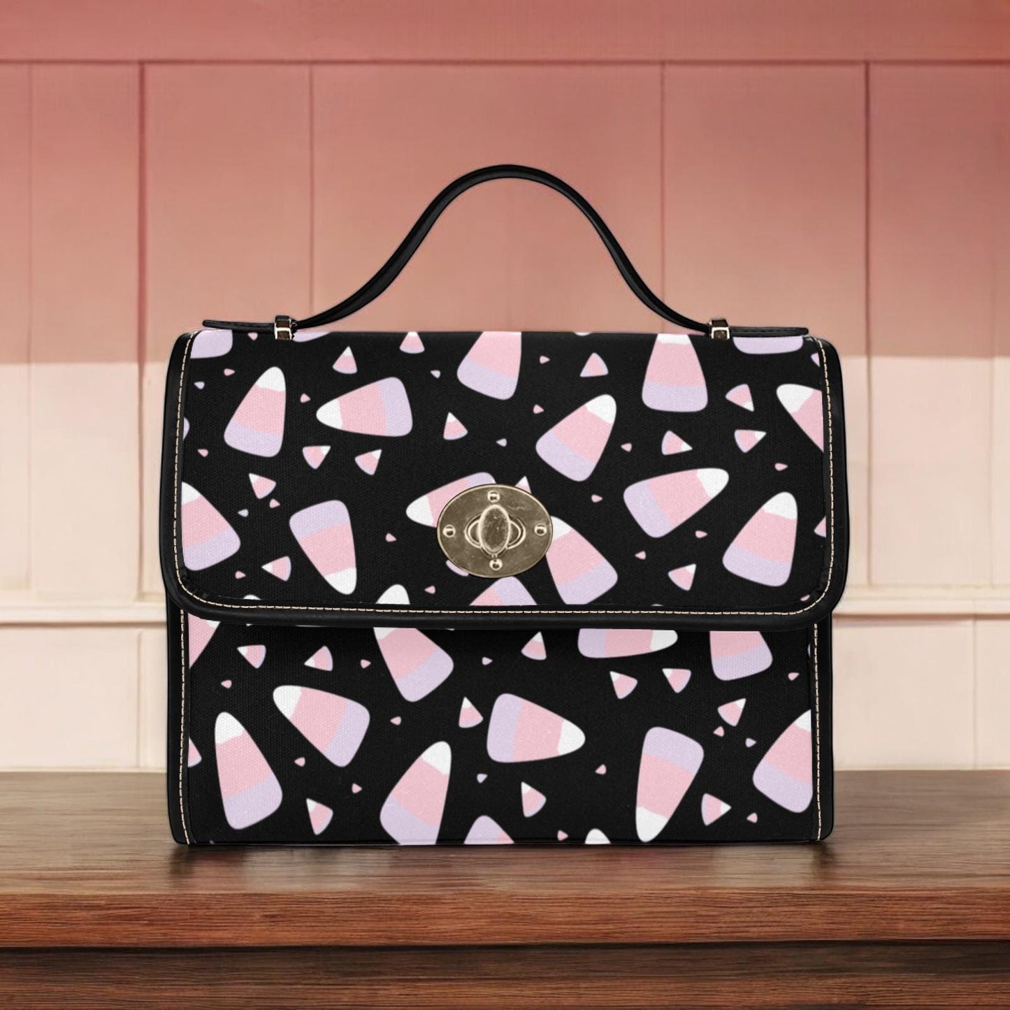 a black and pink purse sitting on top of a wooden table