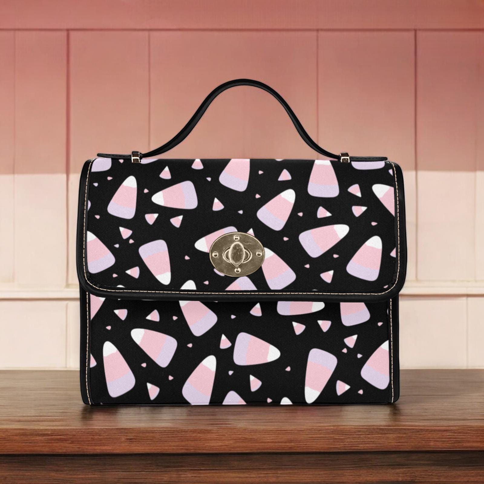 a black and pink purse sitting on top of a wooden table