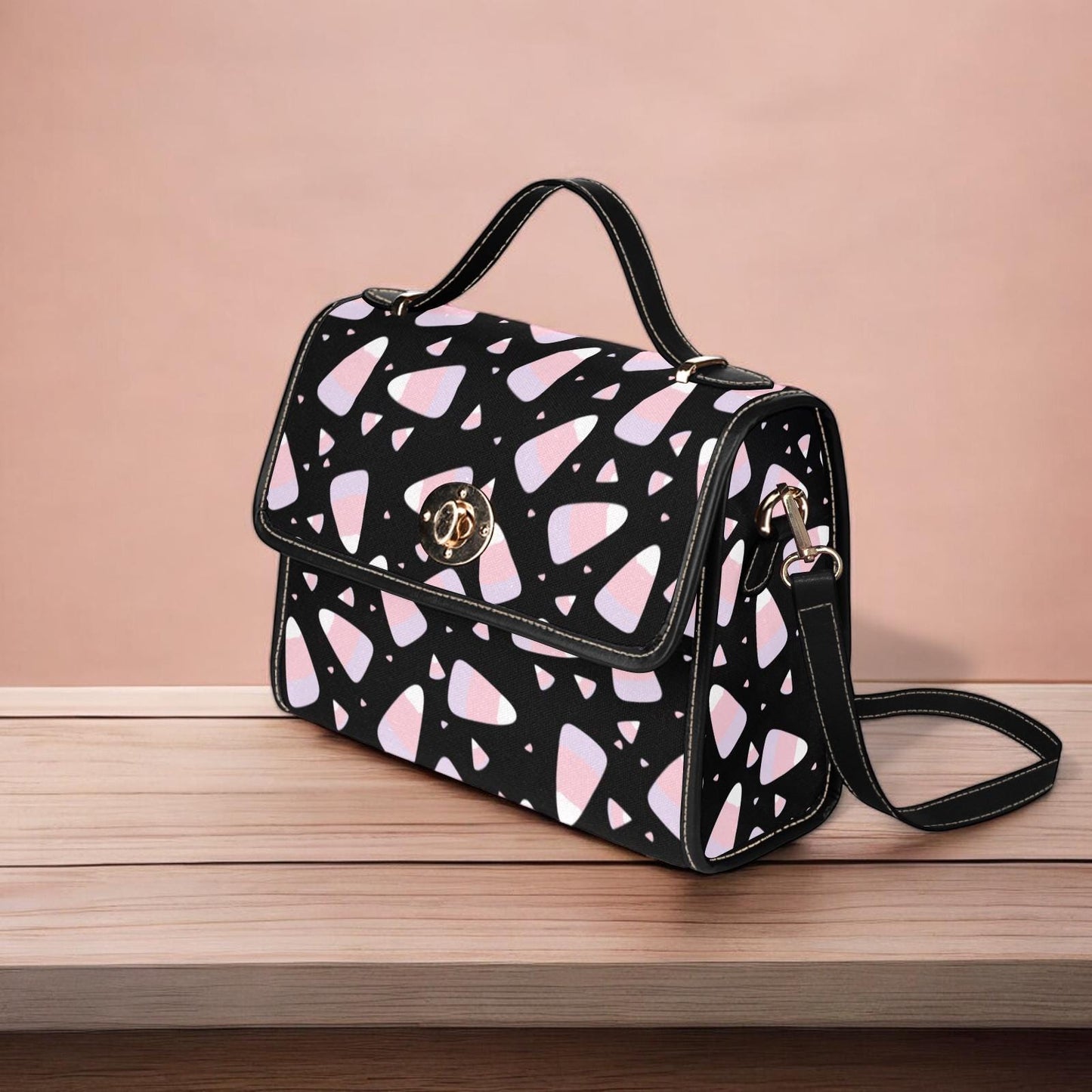 a black and pink handbag sitting on top of a wooden table