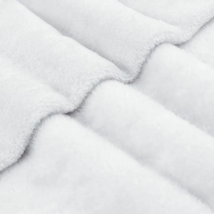 A close-up view of a soft, fluffy white fabric, possibly a blanket or cushion, with a textured and wrinkled appearance.