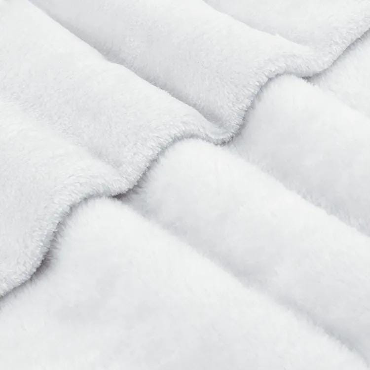 A close-up view of a soft, fluffy white fabric, possibly a blanket or cushion, with a textured and wrinkled appearance.