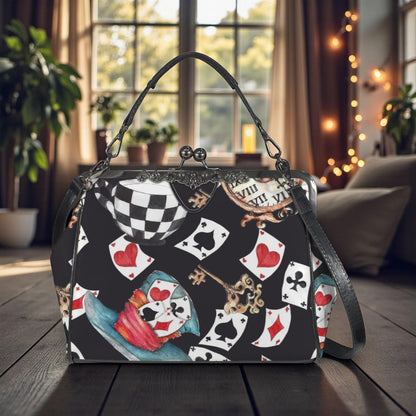 A handbag with a black and white checkered pattern and various playing cards printed on it, placed on a wooden surface in front of a window.