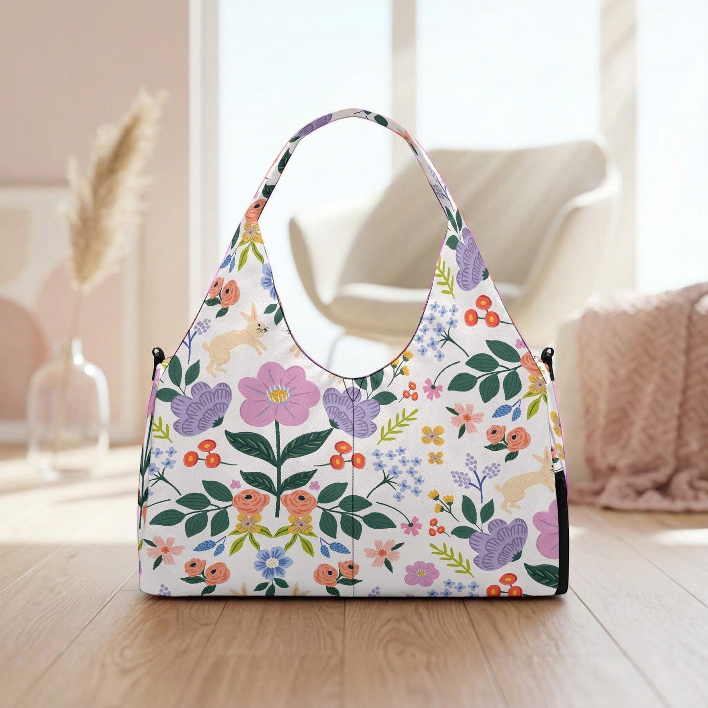 A white handbag with a floral pattern is placed on a wooden surface, with a vase of flowers and a chair visible in the background.