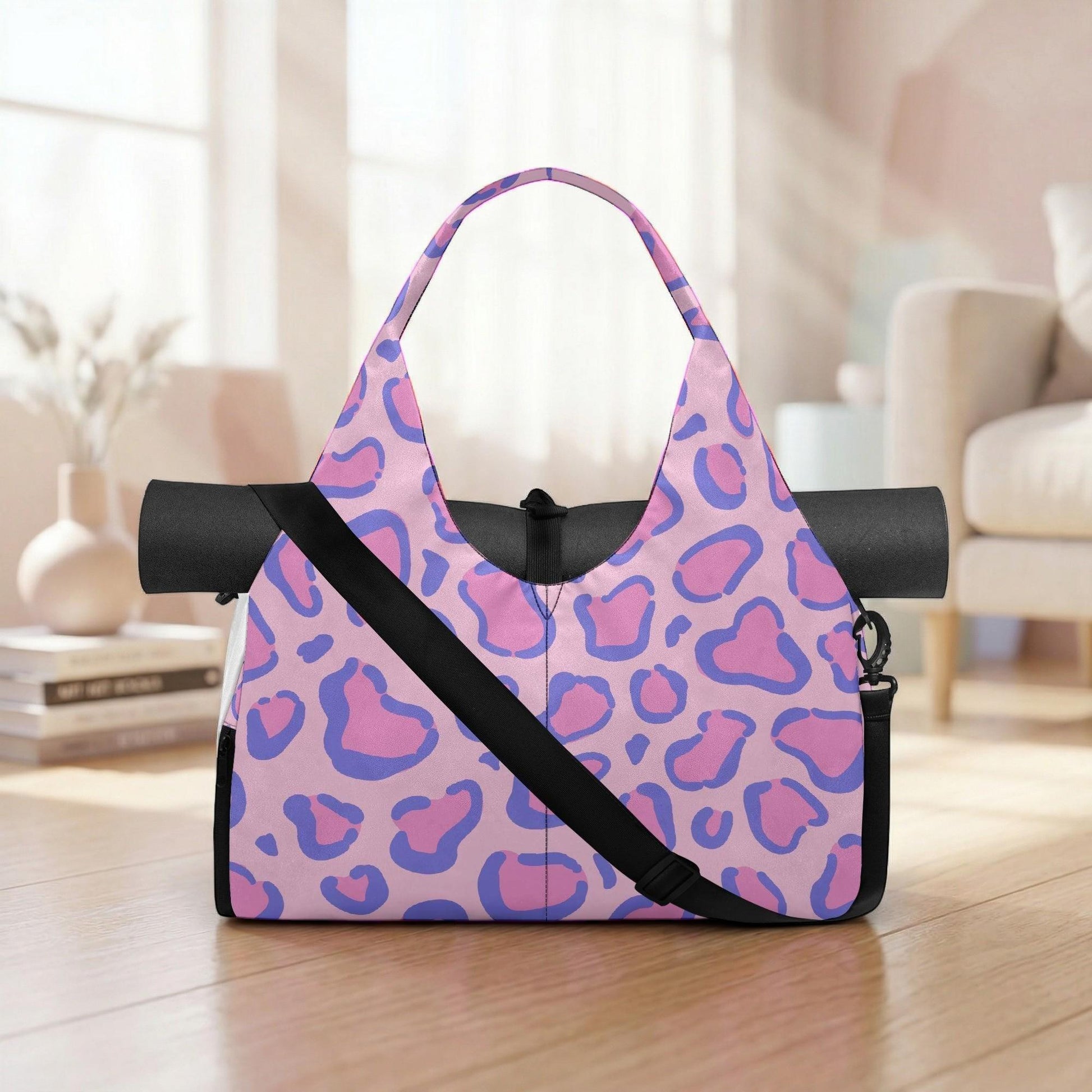 A pink and purple leopard print tote bag with a black strap, placed on a wooden floor in a room with a white couch and a vase.