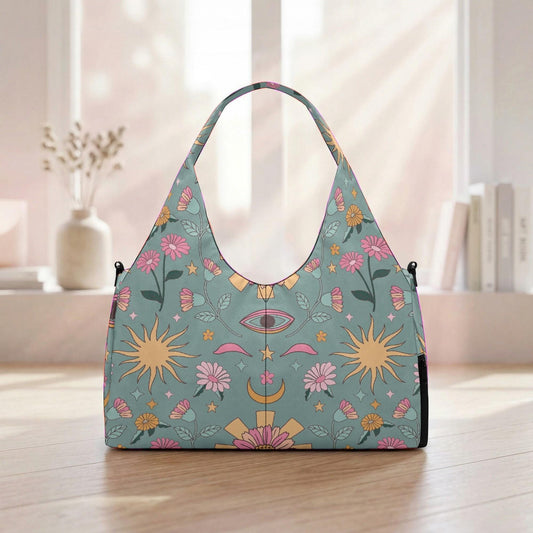 A colorful handbag with a floral and celestial pattern printed on it, placed on a wooden surface near a window.