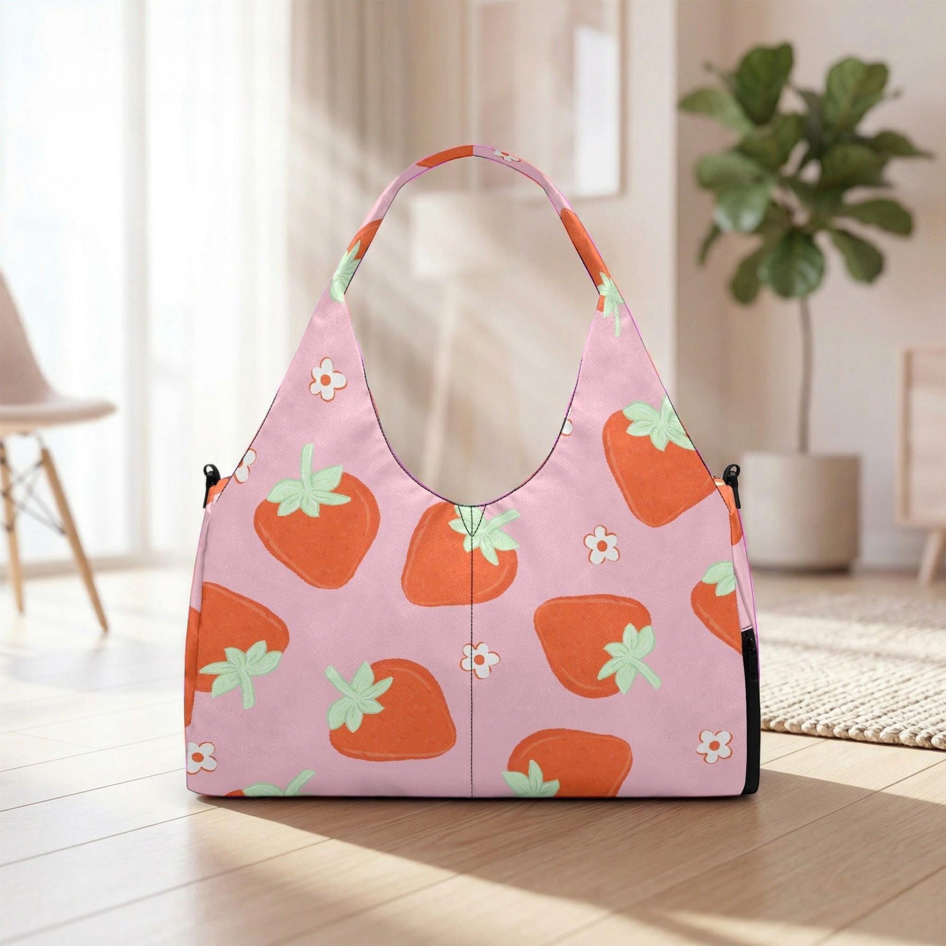 A pink handbag with a strawberry pattern is placed on a wooden floor in a room with a potted plant in the background.