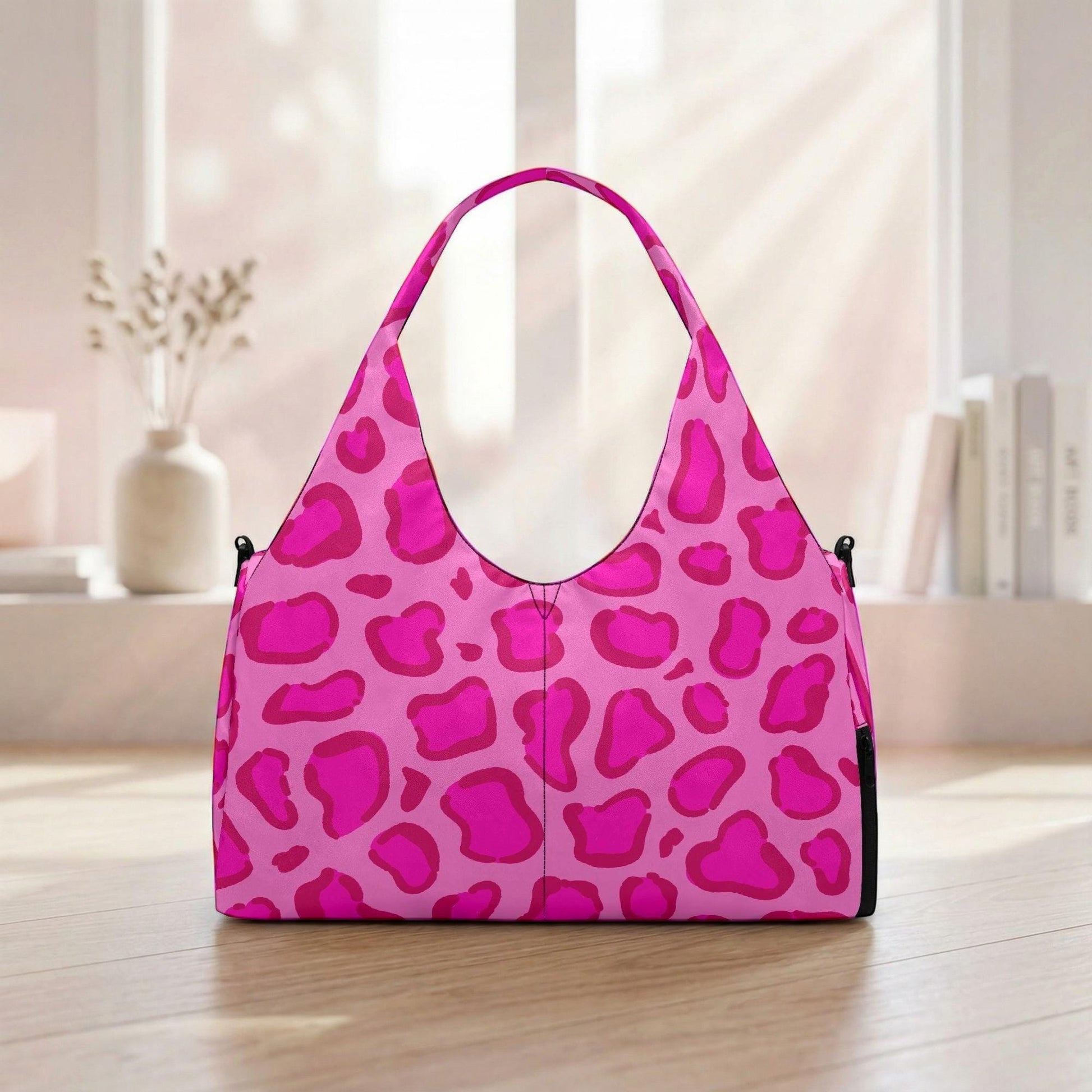 A pink leopard print handbag is displayed on a wooden floor in front of a window.