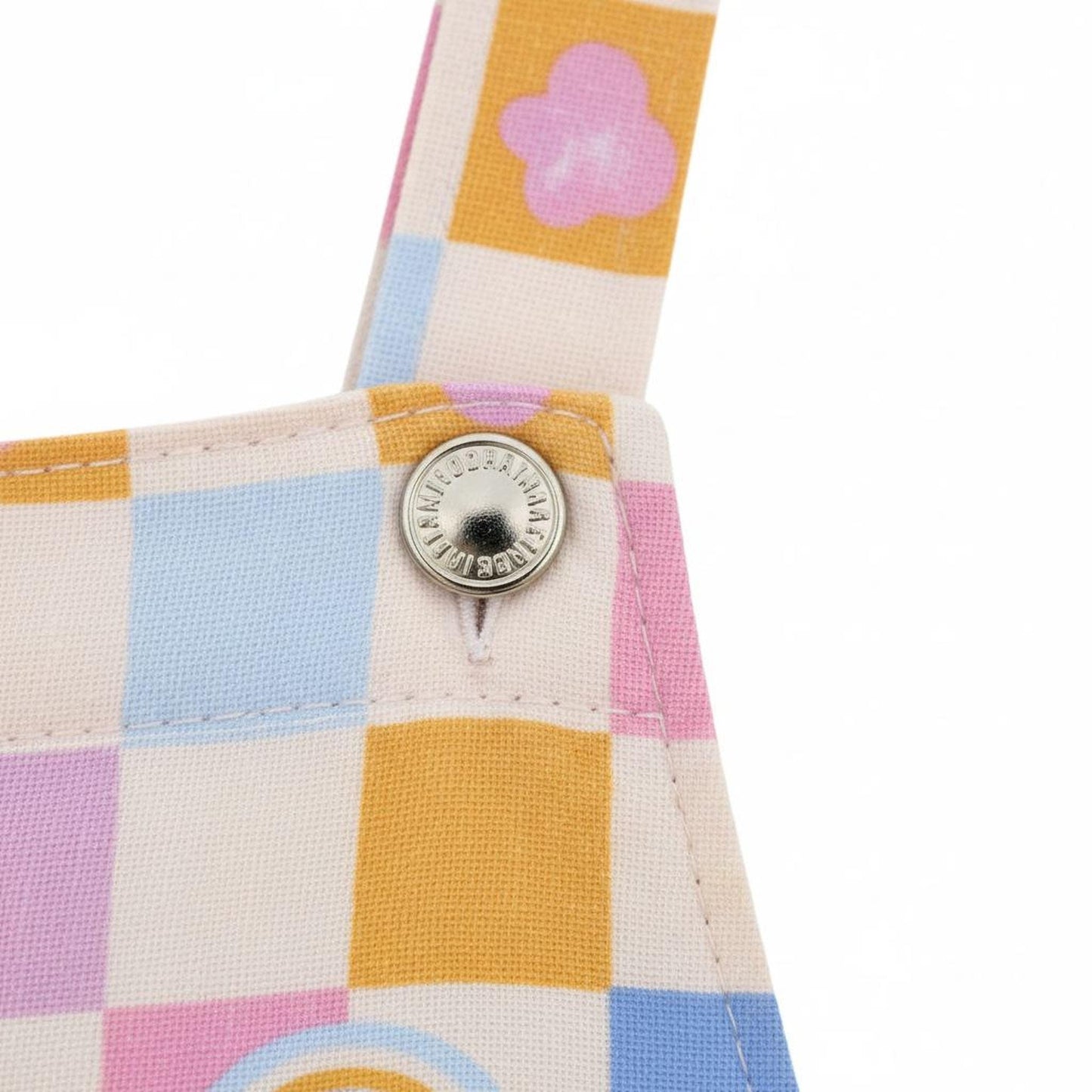 a close-up view of a colorful patterned fabric, possibly a dress or a garment, with a button visible on the fabric.