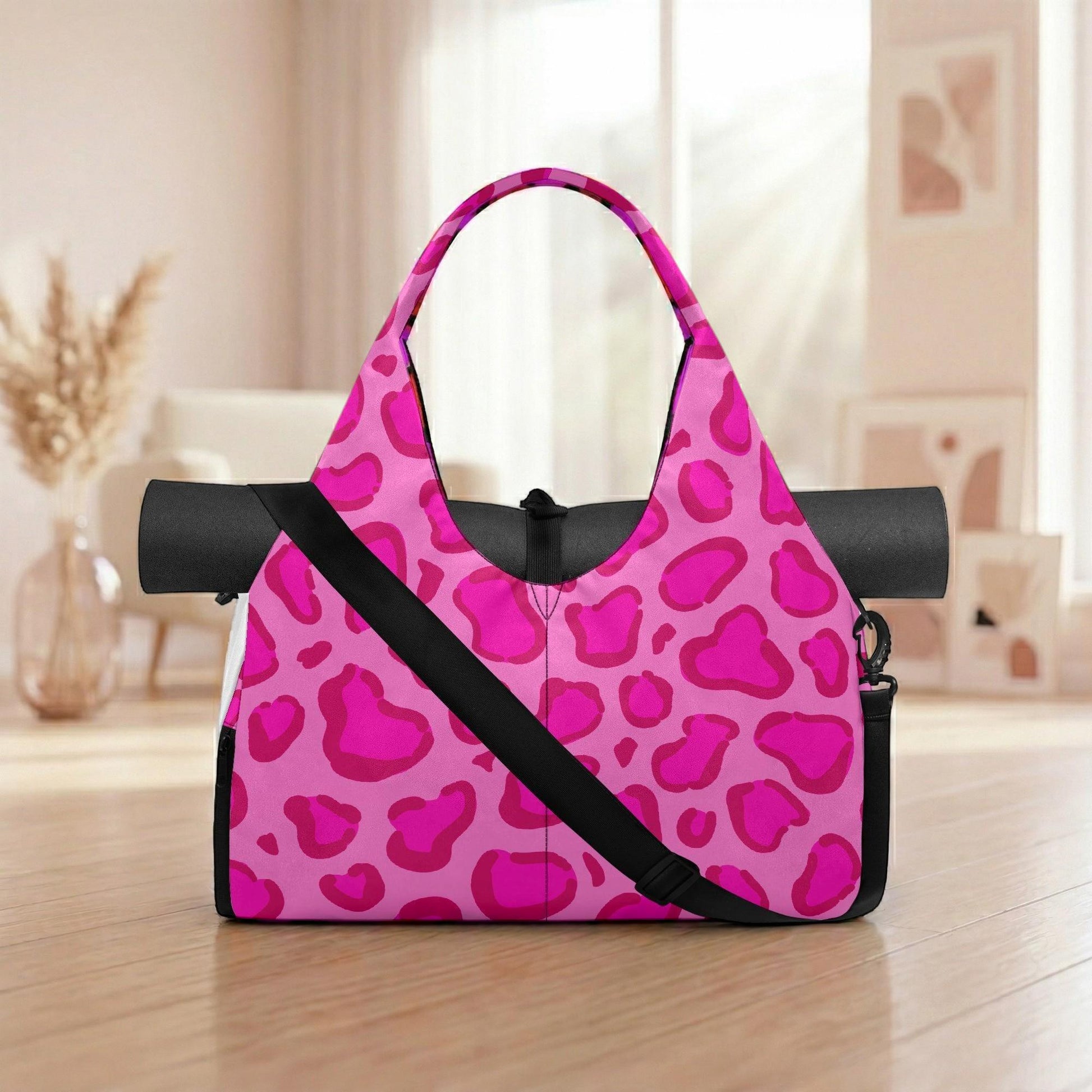 A pink leopard print yoga bag with a black strap is placed on a wooden floor in a room with a window and a vase.