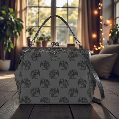 A gray handbag with a dragon pattern printed on it, placed on a wooden surface in front of a window with curtains and plants.