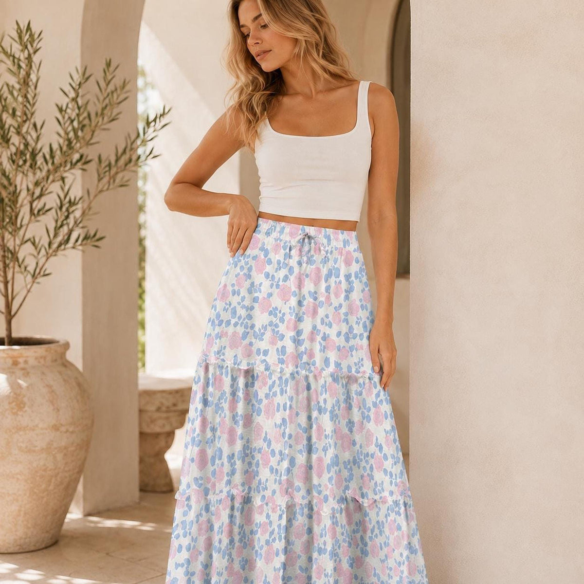 Close-up of the blonde model posing in the white crop top and pink and blue floral tiered maxi skirt.