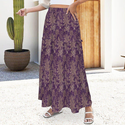 A woman wearing a purple floral maxi skirt and white strappy heels standing near a potted cactus.
