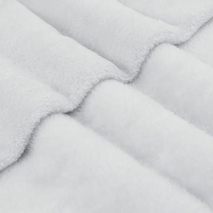 A close-up macro view of soft, plush white sherpa fleece fabric folded in gentle waves.