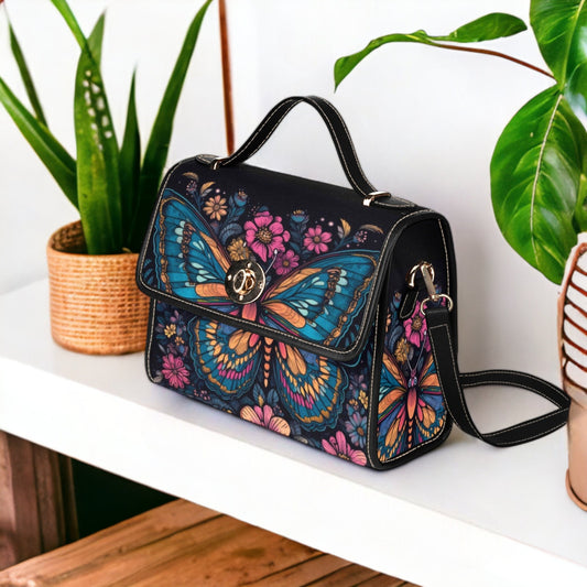 a hand painted butterfly purse sitting on a shelf next to a potted plant