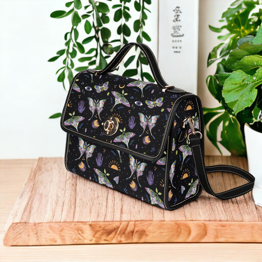 a black handbag sitting on top of a wooden table